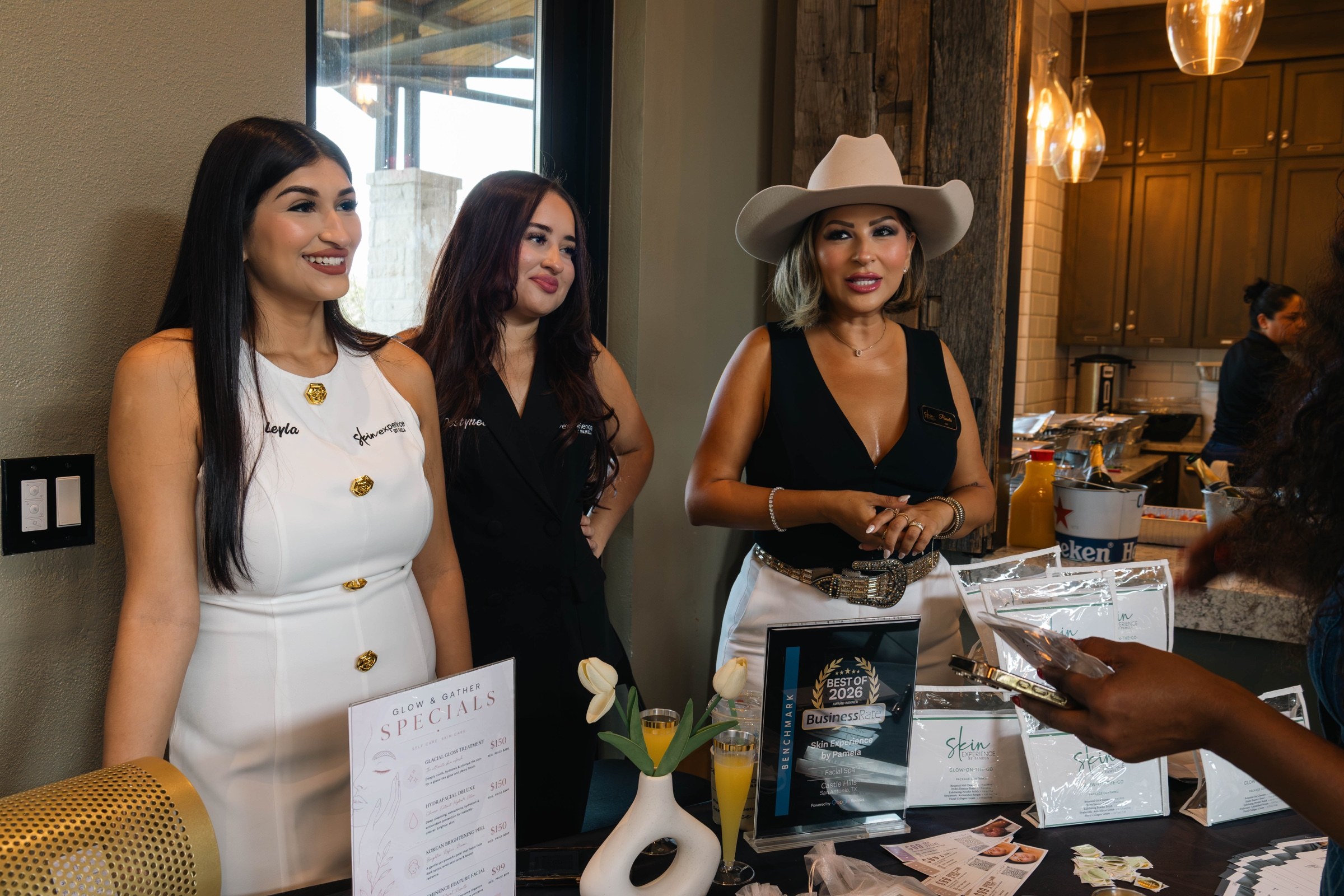 Three women smile and talk with an attendee at an event partner table